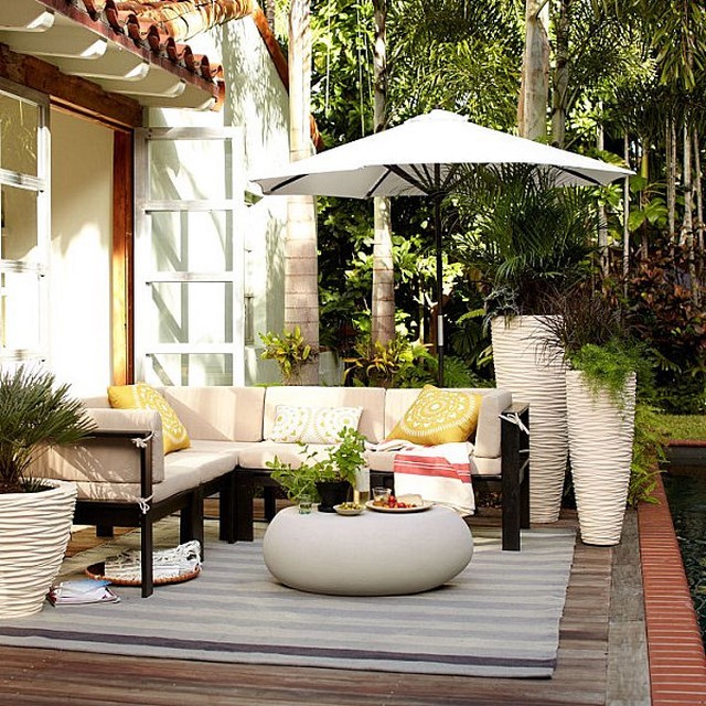 diseño de jardin macetas elegantes claros sombrilla