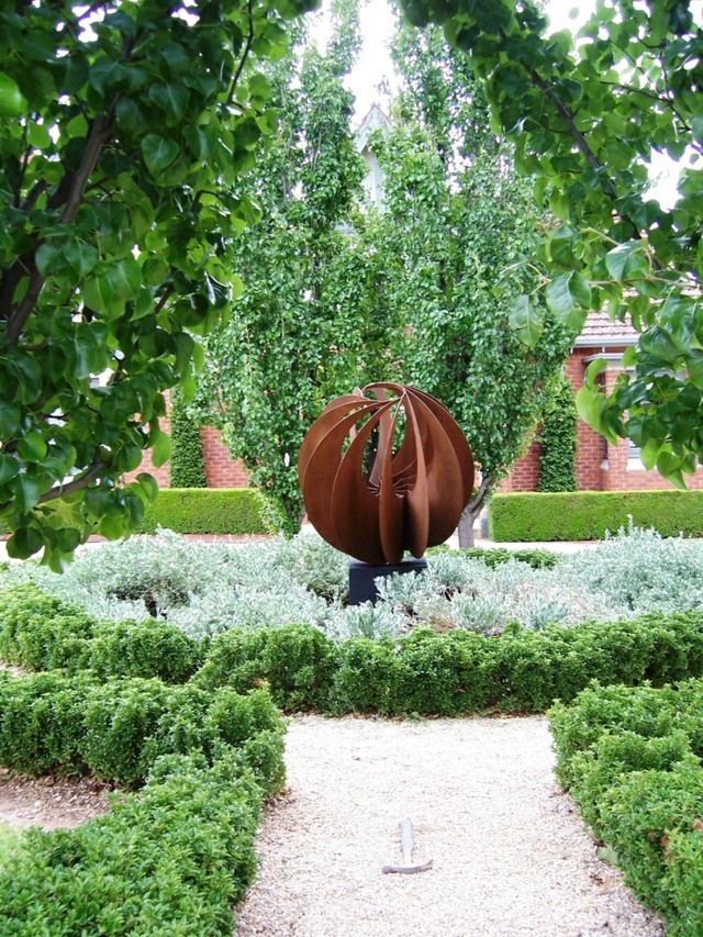 esfera acero camino grava arboles escultura