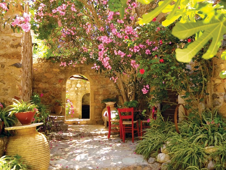 jardín mediterraneo con sillas rojas jardin mediterraneo rustico paredes piedra ideas