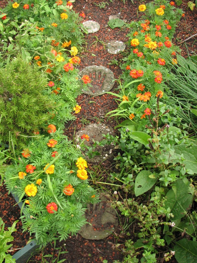 piezas redondas manos hormigon sendero flores marcado