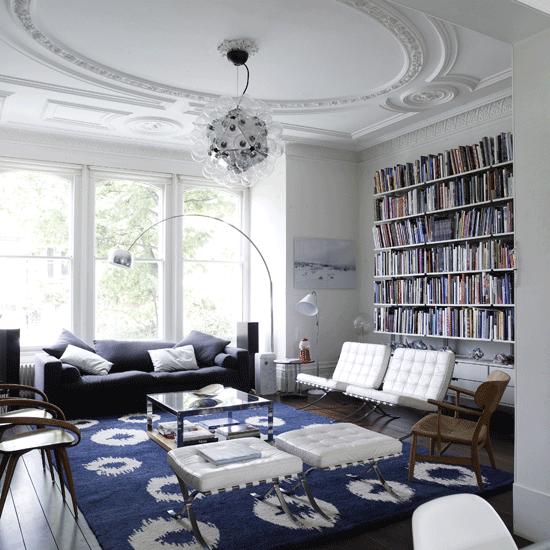 salon estilo moderno estanterias libros butacas cuero blanco