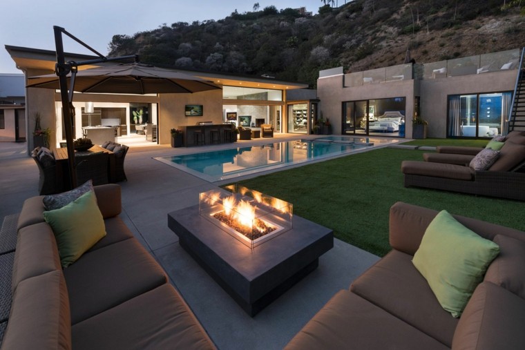 diseño de jardín moderno con zonas de descanso jardin moderno sofas marrones chimenea