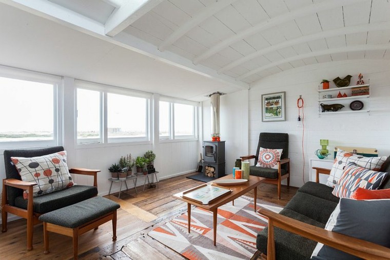 chimenea y paredes blancas en el salón con diseño escandinavo mesa madera sofa negra salones diseno escandinavo ideas
