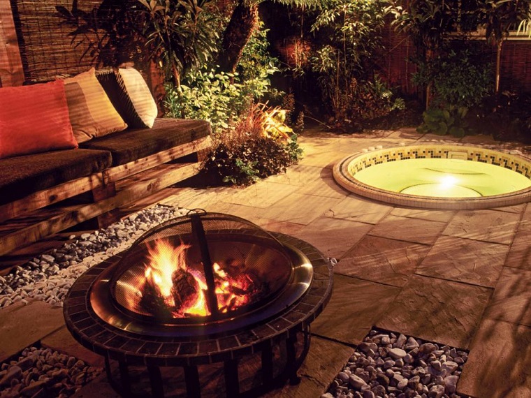 Pozo o plato de fuego y muebles modernos en el jardín