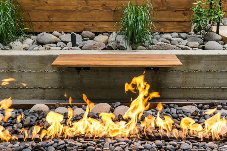 Pozo o plato de fuego y muebles modernos en el jardín