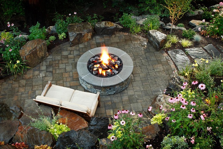 Pozo o plato de fuego y muebles modernos en el jardín
