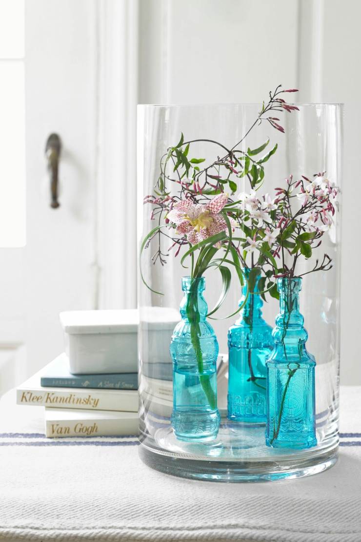 arreglos florales pocos tallos jazmín dispuestos botellas azules vintage pieza central elegante especial ideas