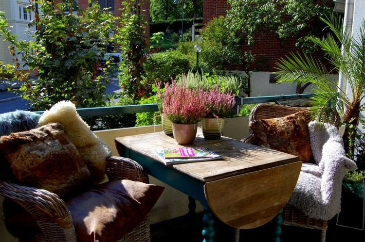 mesa de madera y sillas cómodas en el balcón decoracion facil balcon otono invierno ideas