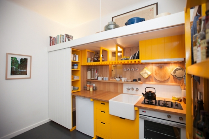 Mini cocina genial con armarios amarillos en un estudio de 23 metros