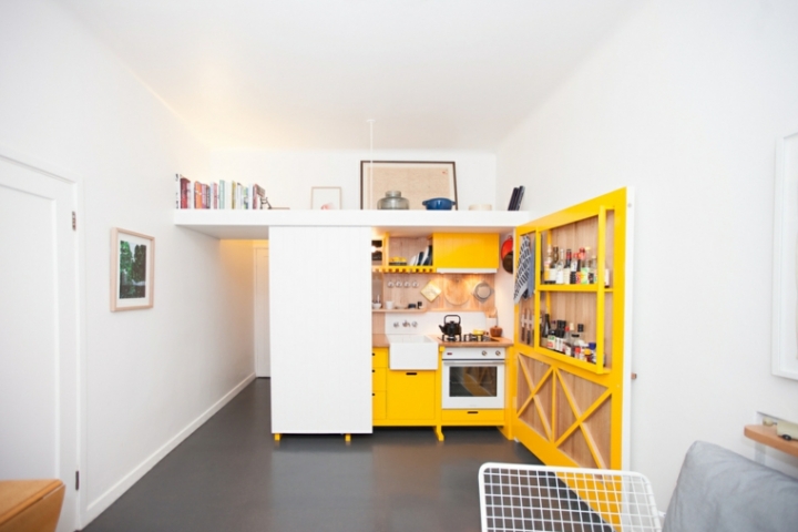 Mini cocina genial con armarios amarillos en un estudio de 23 metros