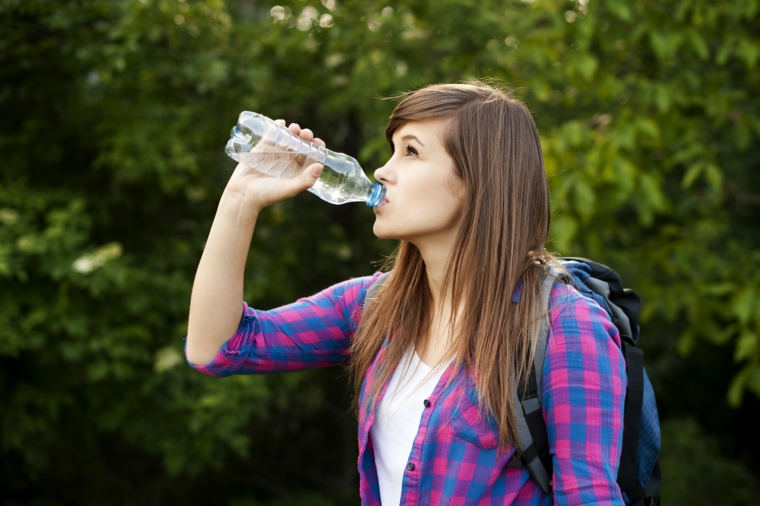 chica-tomando-agua-botella-plastico