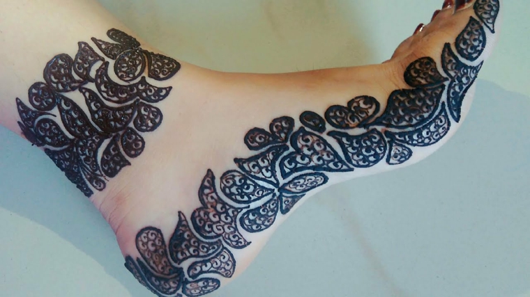 t rnrnThinking about getting a henna tattoo? You might be wondering whether it's better to go to a professional or save some money and do it yourself at home. Well, the choice is yours. If you have an artistic nature, why not give it a try?
Let us tell you one thing: the list of henna body art and temporary tattoo ideas is endless. And that means you can easily choose something interesting but not too difficult for your first experience.
And in case you're unsure about doing it yourself, you can always ask a friend for help. It's an incredible idea for a slumber party, don't you think?
Homemade henna temporary tattoos
Here's a basic instruction on how to make henna paste for tattooing at home. You'll need the following simple ingredients: approximately 10 grams of henna powder, a container, sugar (1 teaspoon), a plastic sandwich bag, strained lemon juice, essential oil (1 teaspoon), and a cone or bottle for application.
Preparation method:
Mix lemon juice (1/8 cup) with henna powder in a bowl. Stir thoroughly until there are no lumps. Add sugar to this mixture. Stir well and pour in the essential oil (lavender, eucalyptus, tea tree will work fine).
Continue stirring until the mixture becomes smooth and silky. Then cover the container with plastic wrap, making sure there are no air bubbles. Keep the paste in a warm place (around 25º degrees) for about 24 hours. Then the paste will be ready to use.
Simply fill the applicator and start creating the chosen design.
Natural henna is safe
Now let's address the most common concerns. Many people wonder if henna is a safe substance. Well, don't worry, natural henna is unlikely to cause an allergy. In general, natural henna does not contain harsh additives or chemical dyes. Although, if you are extremely prone to allergies, try henna on a small area of your skin and wait for 24 hours. If no adverse reaction appears, feel free to use henna without any doubt.
Durability of temporary tattoos
How long can such a tattoo last? Usually, it lasts from 7 to 21 days. But it all depends on different factors such as skin type, body part, and a person's lifestyle.
How to achieve a better and longer-lasting result?
Let the paste dry on your skin for a really long time, like overnight. This way, the dye will penetrate deep into the layers of the skin and stay for a longer period.
So, whether you decide to go to a professional or try it yourself at home, henna tattoos are a fun and temporary way to express your creativity. Give it a go and enjoy the beautiful designs on your skin!<img decoding=