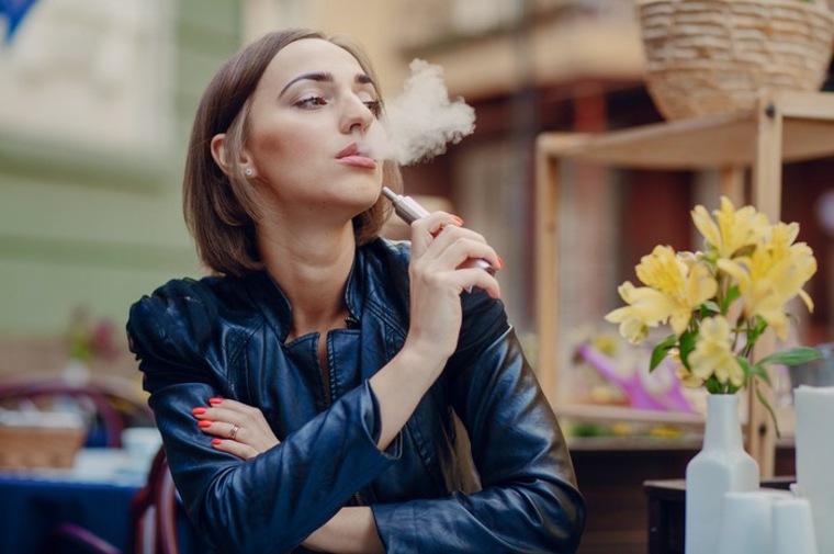 mujer fumando cigarro electrónico