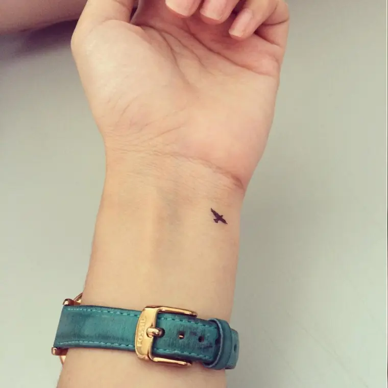mini ave tatuaje pequeño simboliza vuelo partida
